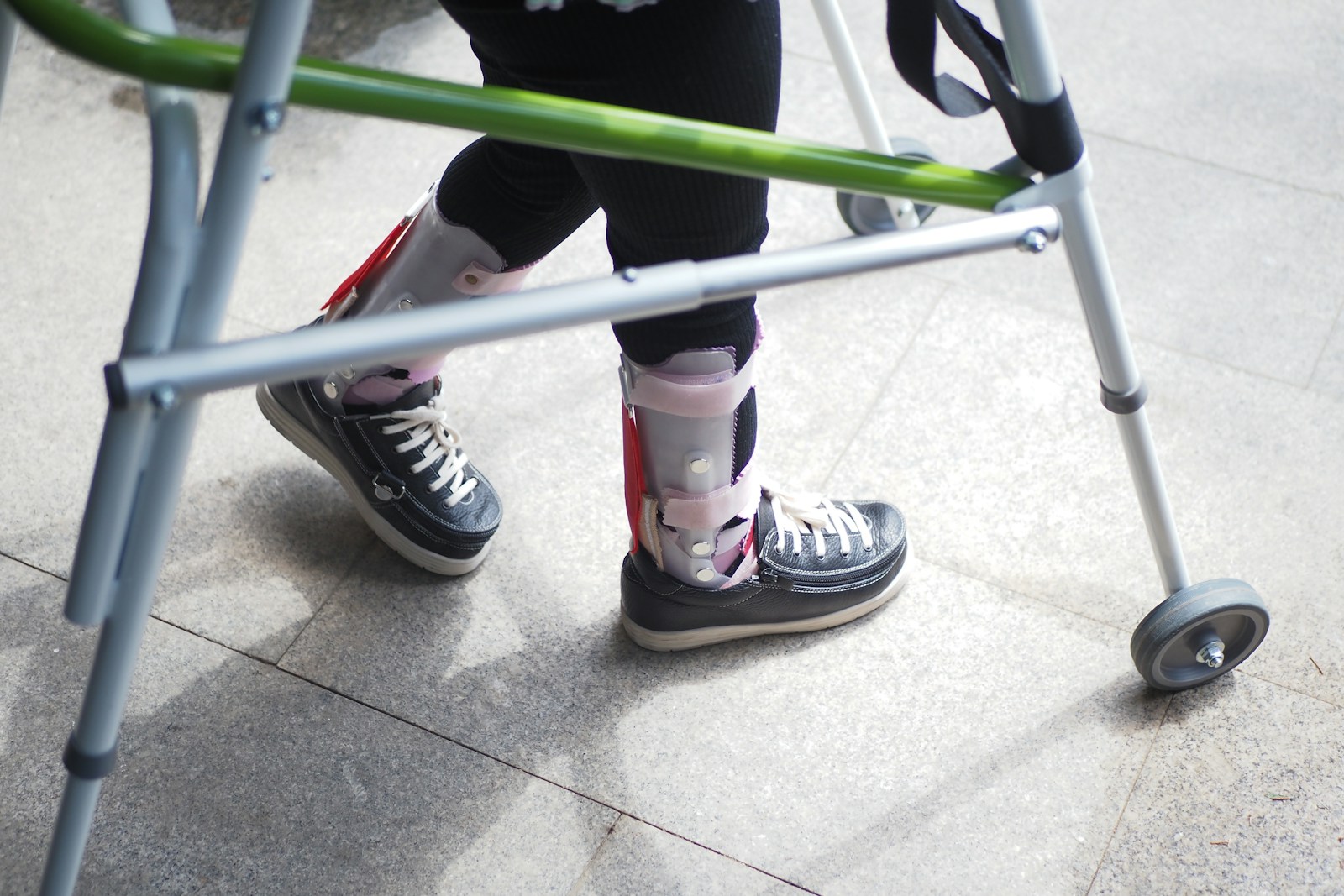 A person standing next to a green walker